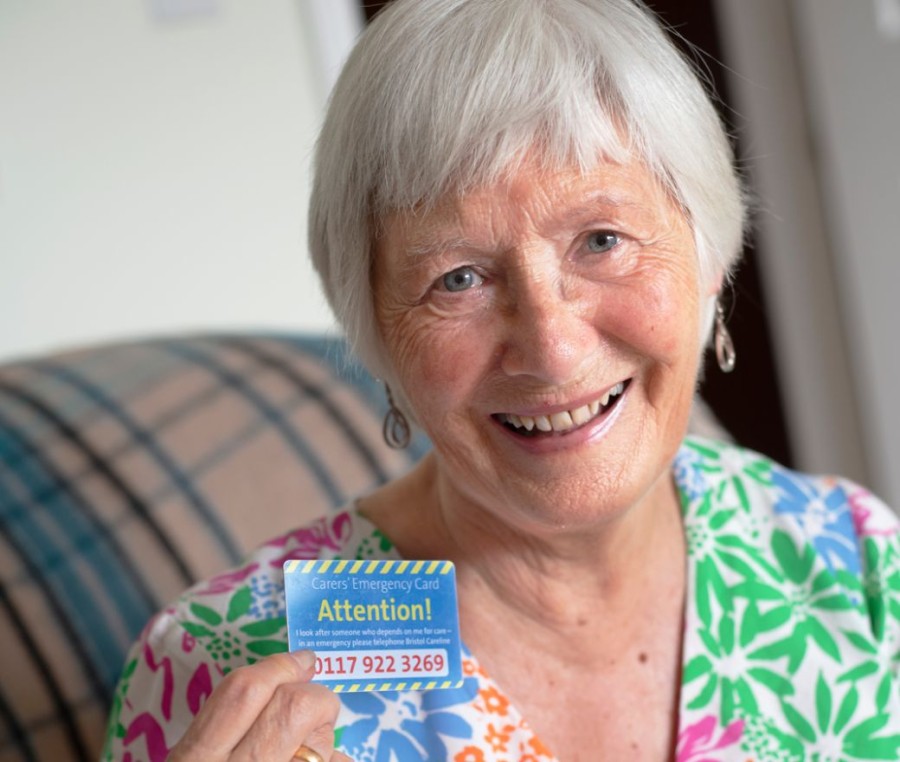 An older carer shows her Carers Emergency Card to the camera