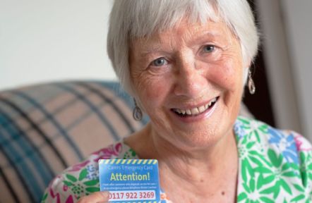 A carer shows her Carers Emergency Card to the camera