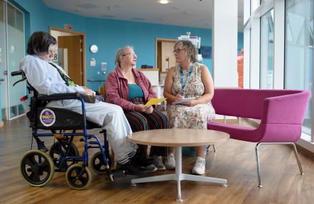A carer support office having a discussion in a hospital with a carer and their cared-for