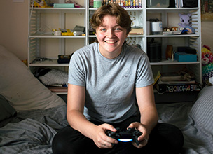 Young adult holding games controller