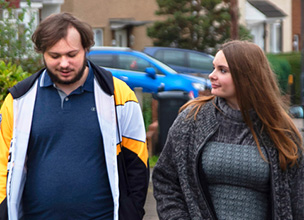 Two people walking down the street