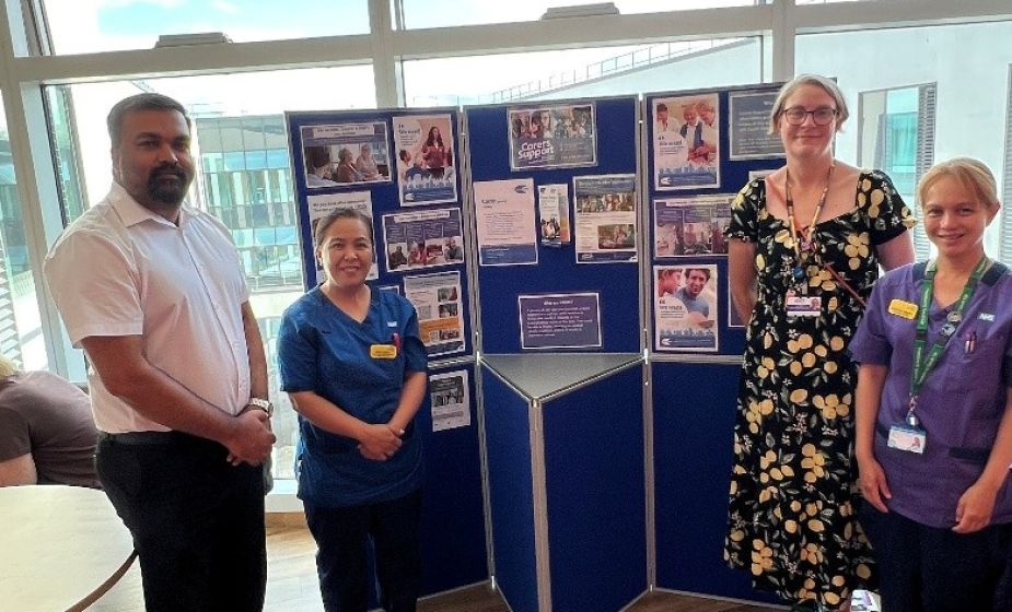 Hospital staff standing beside a carers information display during a carers awareness event on Ward 34 at Southmead Hospital.